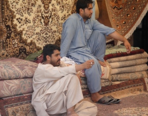 vendors sitting on stacked rugs
